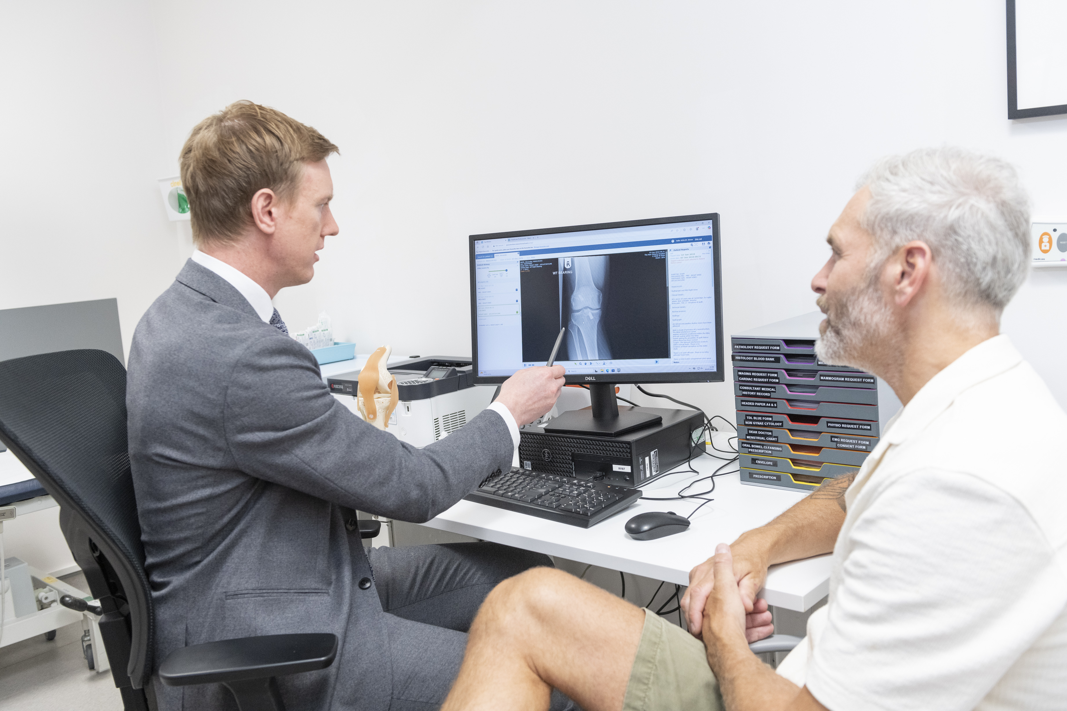 Mr Simon Hislop showing a patient an orthopaedic scan of his knee
