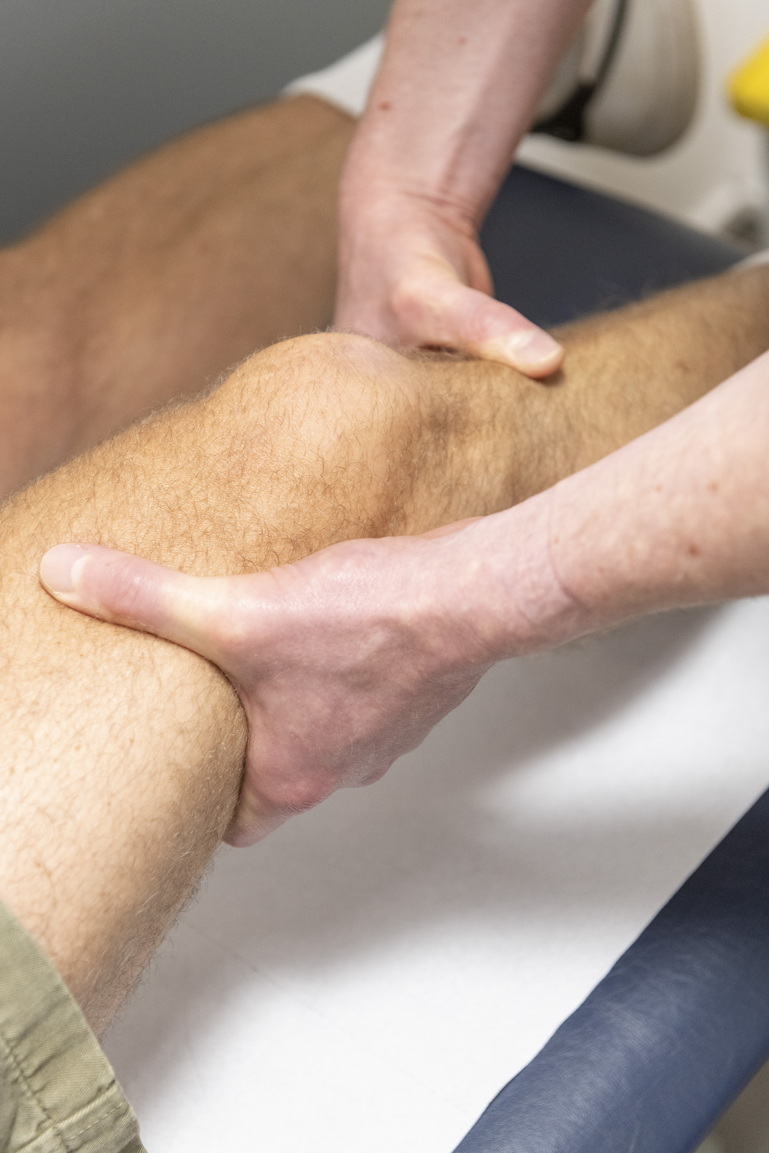 close up of a man's knee being checked by a doctor