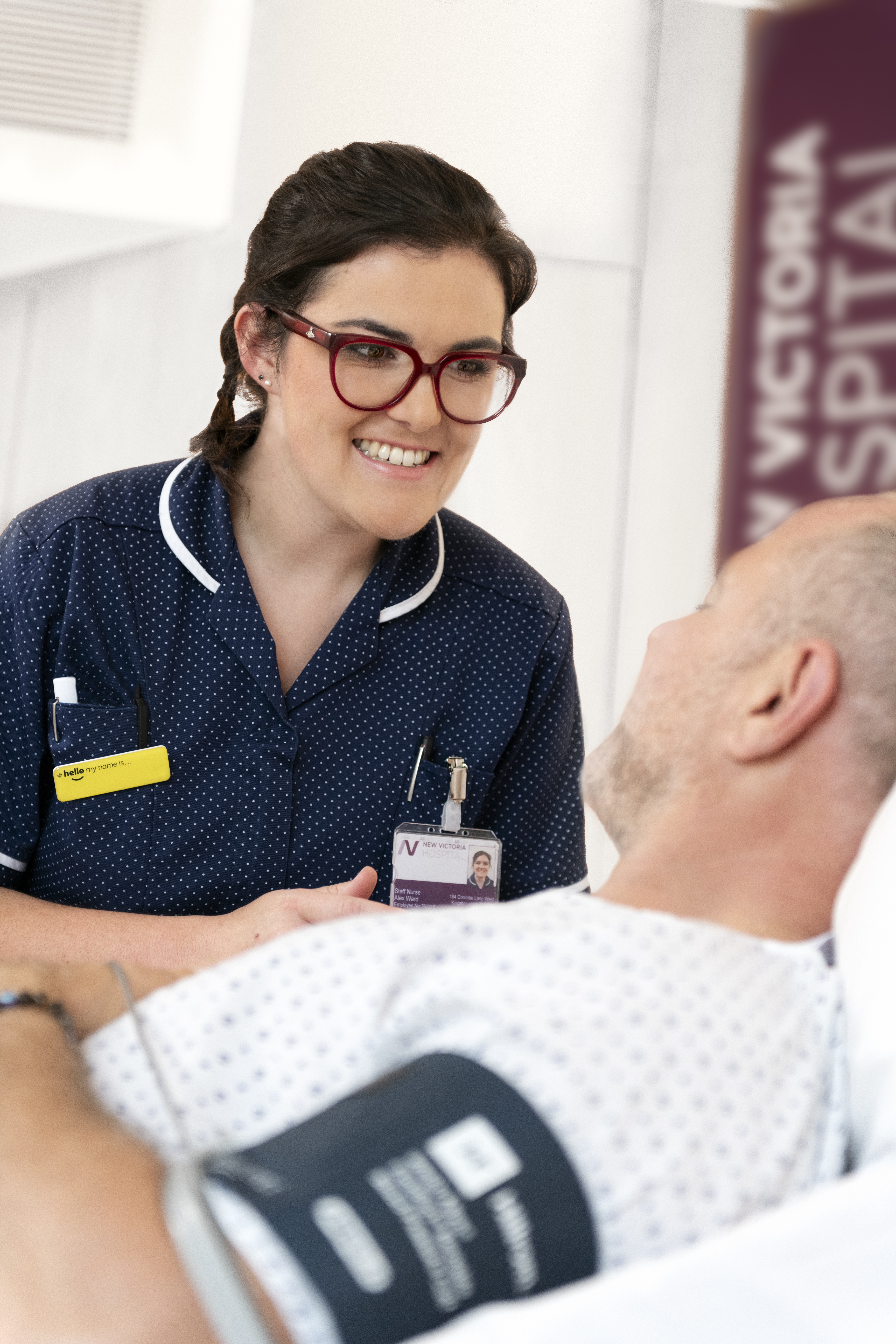 New Victoria Hospital nurse with a patient talking and taking his blood pressure